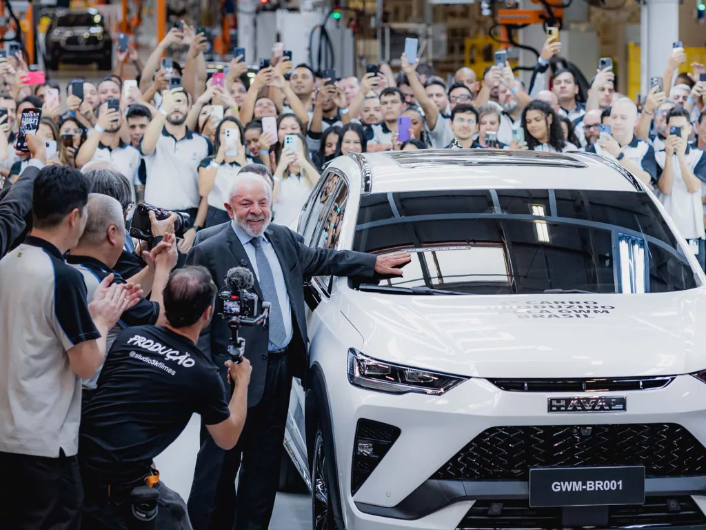 Presidente Lula participou da finalização do primeiro veículo fabricado no país, um Haval H6 GT branco, aplicando o adesivo "fabricado no Brasil". Crédito: Divulgação.